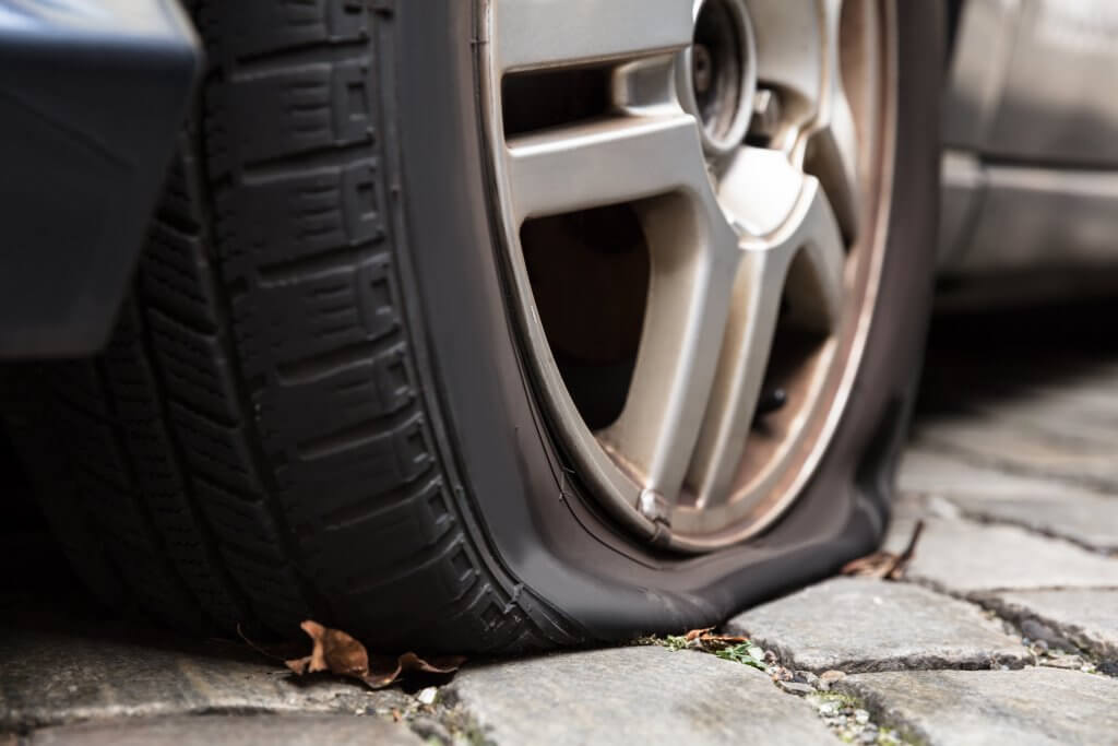 Close-up Of A Damaged Flat Tire Of A Car On The Road
